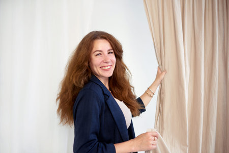 friendly fabric woman salesman in blue jacket shows samples to customers. designer chooses fabric for the curtainsの写真素材