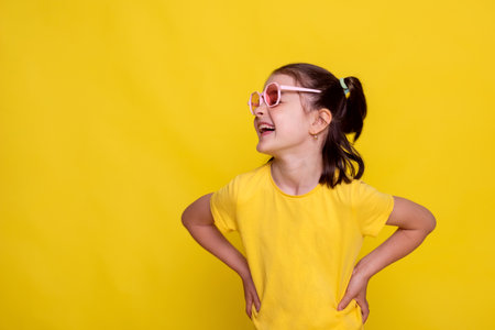 summer banner crazy seasonal sale of children's clothes. child girl in mockup yellow T-shirt on bright yellow backgroundの写真素材