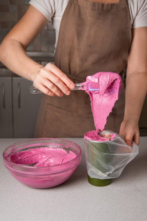 confectioner prepares colored dough for macaroons, cream for pink bright dessertの写真素材