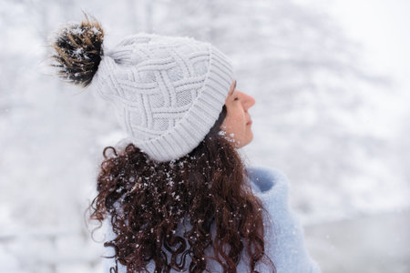 dreamy woman stands under the snow in forest