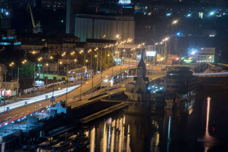 Bustle of the city, the road and the car on the bridge at night by the lightの写真素材