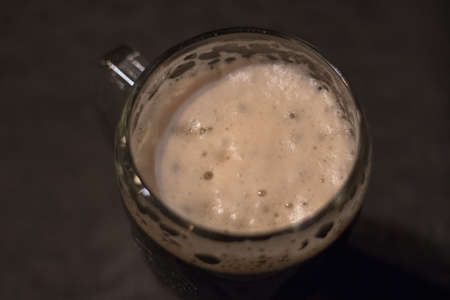 Foam from dark beer in a glassの写真素材