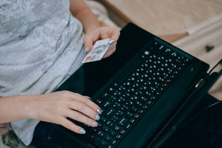 Woman buying online or booking hotel with a laptop and credit card. E commerce conceptの写真素材
