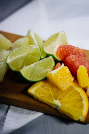 stack of citrus fruits slices. Oranges and lemons limes, grapefruit, pomelo. On wooden tableの写真素材