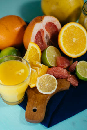 Citrus, oranges, lemons, limes, grapefruit, pomelo on vintage board lemonade on a turquoise backgroundの写真素材