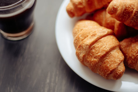 Coffee cup and fresh baked croissants on wooden background. Top View.の写真素材