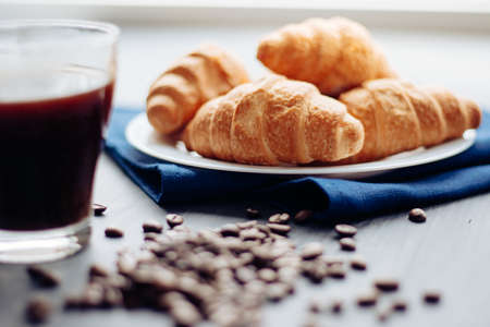 Coffee cup and fresh baked croissants on wooden background. Top View.の写真素材
