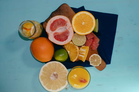 Citrus, oranges, lemons, limes, grapefruit, pomelo on vintage board lemonade on a turquoise backgroundの写真素材