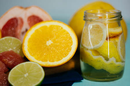 Citrus, oranges, lemons, limes, grapefruit, pomelo on vintage board lemonade on a turquoise backgroundの写真素材