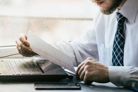 Concentrated businessman working on laptop at desk in office