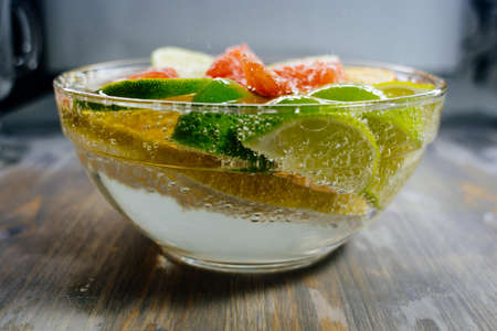 Citrus in water with bubbles in transparent plate Oranges, lemons, greyfrut, Pamela lemonadeの写真素材