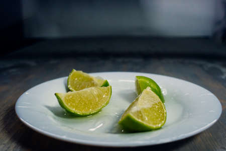 tropical fruits citrus lime fall deeply under water with a big splash on plateの写真素材