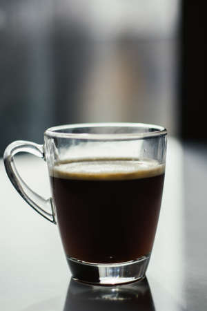 Black espresso coffee with heady froth in a glass mug or cupの写真素材