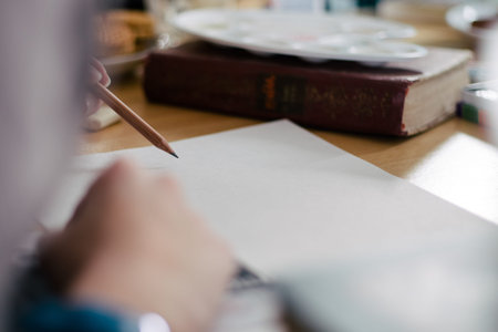 business, education, planning and people concept - close up of female hands with pencil, coffee and cookies drawing scheme to notebook on tableの写真素材
