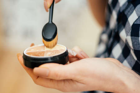 Close up shot. Make-up artist taking blusher from makeup palette in white room. Beauty, makeup and fashion conceptの写真素材