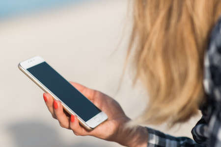 Beautiful girl holding a smartphone in the hands of a green screen green screen, hand of man holding mobile smart phone with chroma key green screen on white background, new technology conceptの写真素材