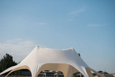 Landscape at seaside with tents and umbrellas on the beach, under blue sky withの写真素材