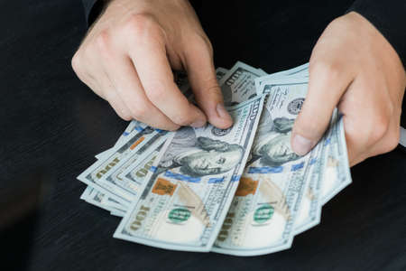 hand recount dollars. the man counts the money. new hundred-dollar billsの写真素材