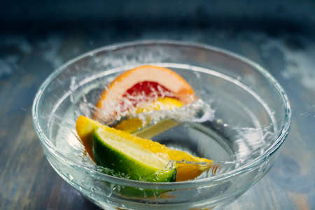 tropical fruits citrus fall deeply under water with a big splashの写真素材