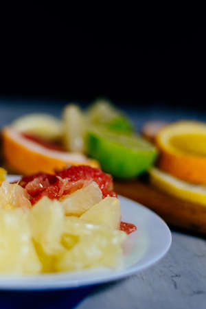 Various citrus fruit cut into slices orange, lemon, lime, grapefruit, pomelo. Spread out on a wooden board on a vintage background of natural woodの写真素材