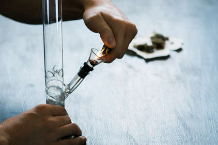 man using a smartphone. Bong and medical marijuana, cannabis thc flower Sativa and Indica Close up on a black background. lifestyle Concepts the legalization of marijuana in the world and theの写真素材