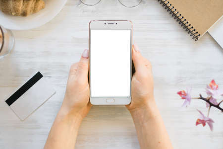Woman holding a credit card and using cell phone for online shopping.の写真素材