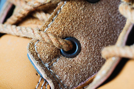 Macro yellow suede boots shoes and shoelaces on wooden background. Autumn or winter shoes. Macro