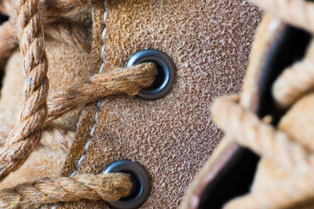 Macro yellow suede boots shoes and shoelaces on wooden background. Autumn or winter shoes.