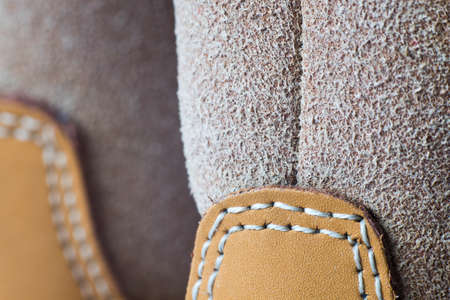 Macro yellow suede boots shoes and shoelaces on wooden background. Autumn or winter shoes. Macroの写真素材