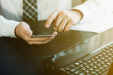 man working on a smartphone in office close-up