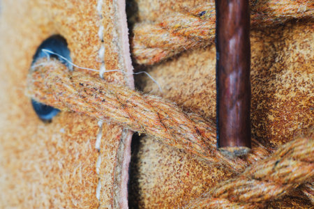 Macro yellow suede boots shoes and shoelaces on wooden background. Autumn or winter shoes. Macro