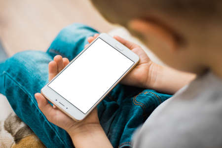 Little boy use mobile phone. White, blank, isolated screen White screen for mock up for mockup isolatedの写真素材