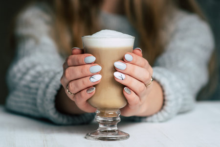 Coffee latte art on woman hand in coffee shop in vintage