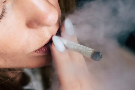 smokes weed cannabis, A woman joint in his hands. Smoke on a black background. Concepts of medical...