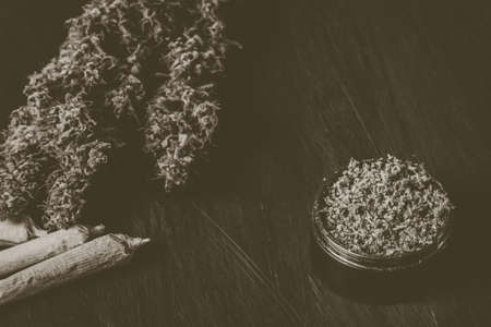 Macro of marijuana with trichomes and crushed grass in a grinder for chopping a canapis on a black tableの写真素材