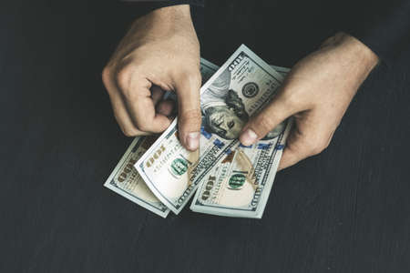 hand recount dollars. the man counts the money. new hundred-dollar billsの写真素材