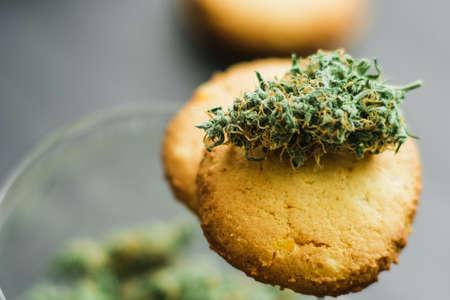 Cookies with CBD cannabis and buds of marijuana on the table.の写真素材