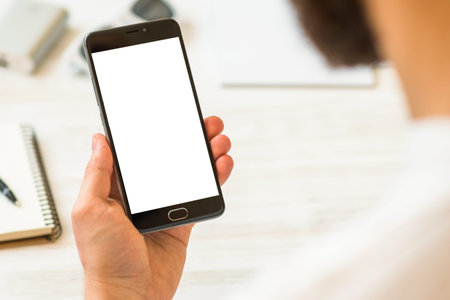 A black smartphone mock up in the hands smartphoneholding hand credit card and . Online payments...