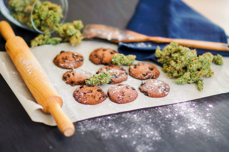Cookies with cannabis and buds of marijuana on the table. Concept of cooking with cannabis herb....