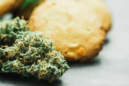 Cookies with cannabis and buds of marijuana on the table. A can of cannabis buds Concept of cooking with cannabis herb. Treatment of medical marijuana for use in food, use CBDの写真素材