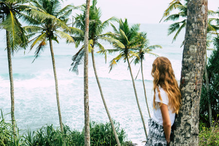 Woman under palm tree at beach
