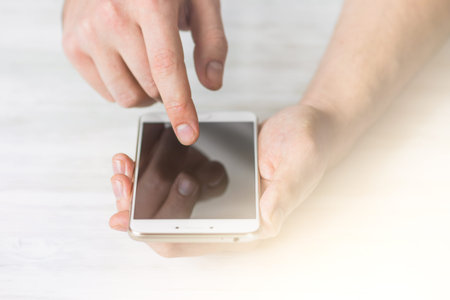 Hipster using a touch screen smart phone hands close up, vintage colors