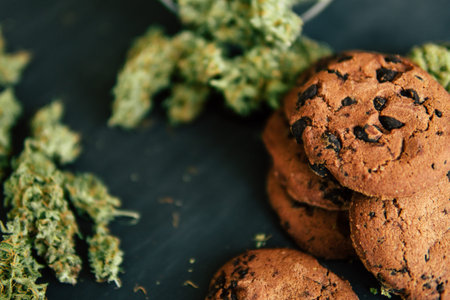 Cookies with cannabis and buds of marijuana on the table. Concept of cooking with cannabis herb....