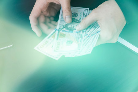 hand recount dollars. the man counts the money. new hundred-dollar bills