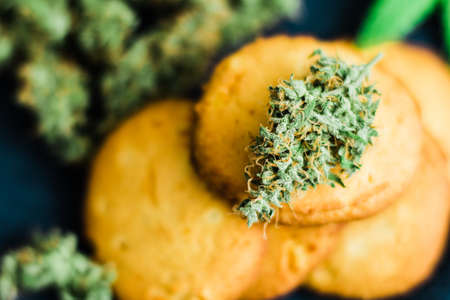 Cookies with cannabis and buds of marijuana on the table.の写真素材
