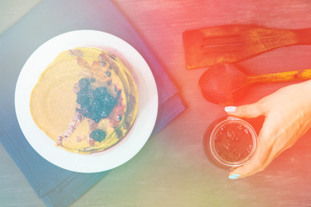 Delicious golden pancakes with fresh blackberries and blackberry jam.