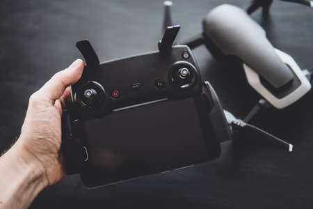 Remote with antennas and a smartphone to control the drone in the hands. Mate color. The concept of using drones in life and industry. . Innovation photography concept.の写真素材