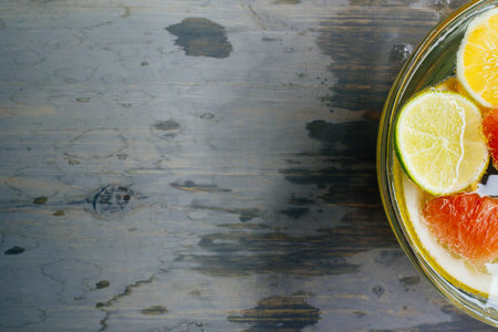 Citrus in water with bubbles in transparent plate Oranges, lemons, greyfrut, Pamela lemonade Space for signature on wood textureの写真素材