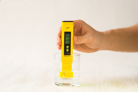 A hand with a PH measuring instrument. Bad indicators of drinking water. Rigid water. Tap drinking...
