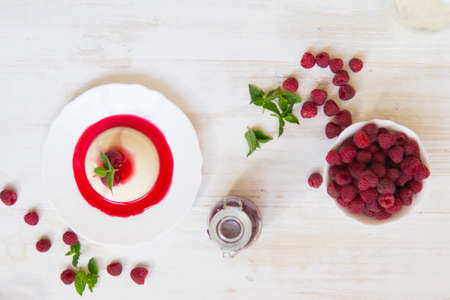 Close up top view. Light background. Summer dessert. Panakota with raspberries. Vertical shot.の写真素材